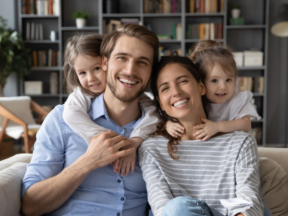 Portrait of young family with small daughters at home